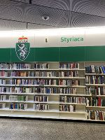 Blick auf ein Regal mit Büchern. Im Hintergrund ein grüner Schriftzug 'Styriaca'.